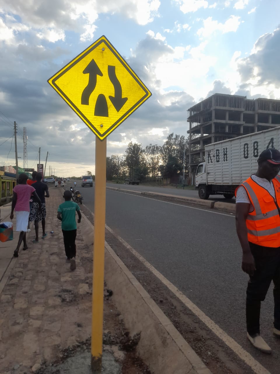 Dual carriageway warning road sign installed in concrete on pavement